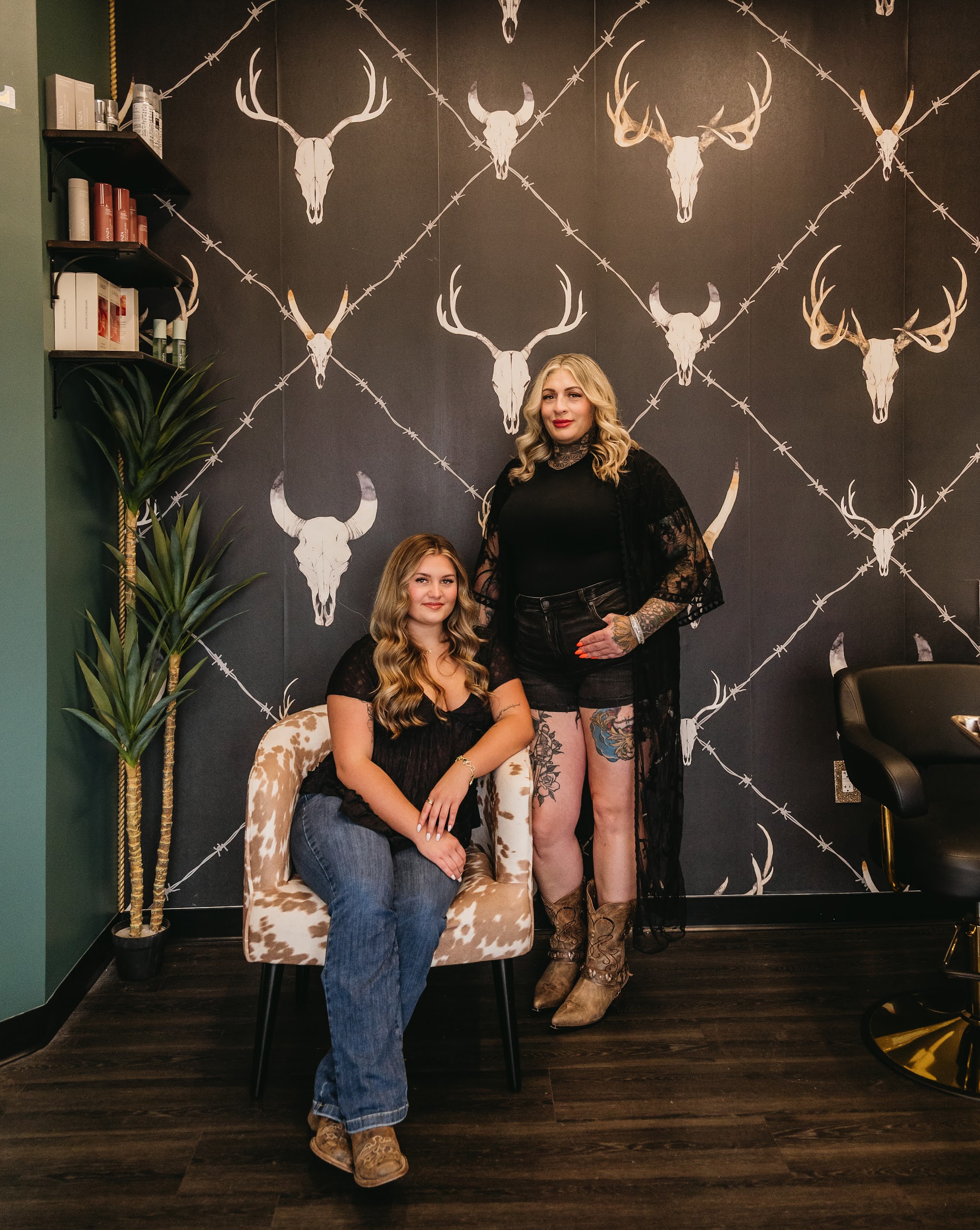 Two members of our team in front of the antler wallpaper